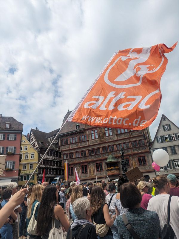 attac-Fahne und Menschen vor Tübinger Rathaus