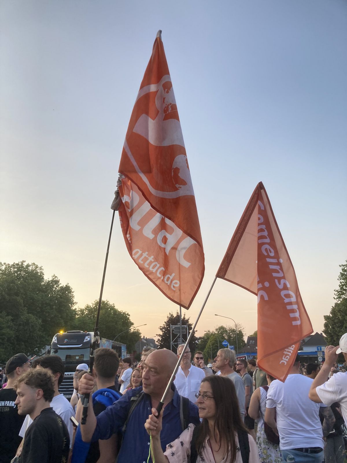 zwei Aktivistis mit Attac-Fahnen
