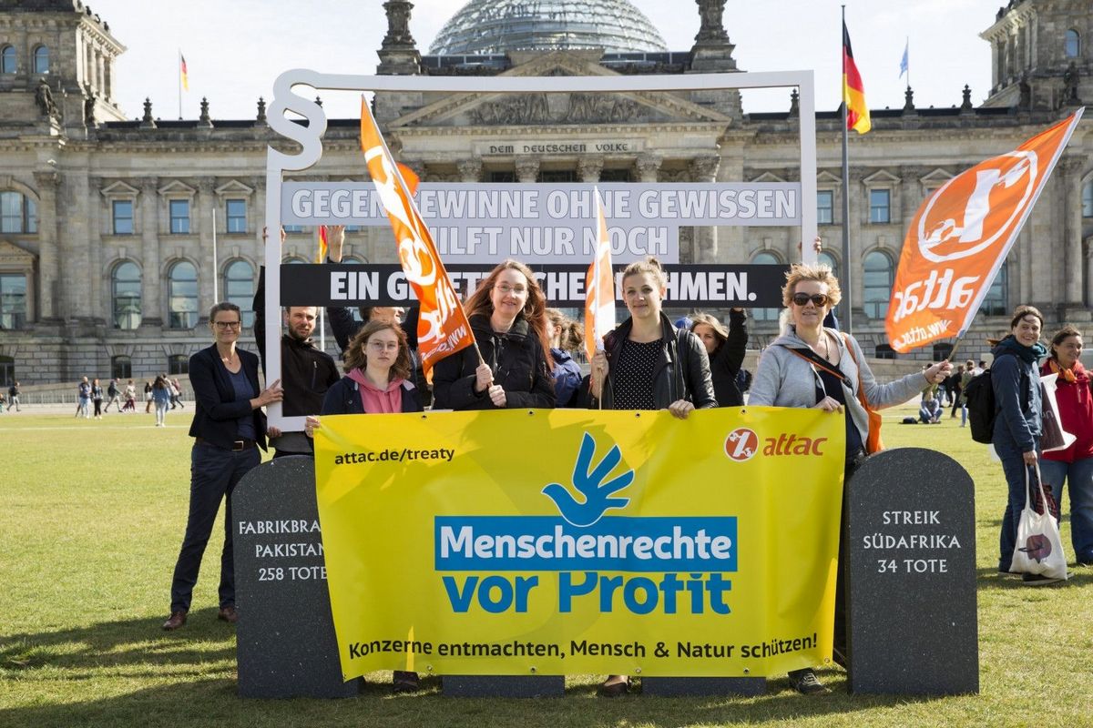 Attacies mit Banner Menschenrechte vor Profit - dahinter Rahmen mit Schrift 'Gegen Gewinne ohne Gewissen hilft nur noch ein gesetzlicher Rahmen'