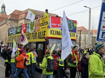 Demobus mit Bannern "Klimastreik" und "Gute Arbeit und Mobilität für alle" + Bannern verschiedener Organisationen, davor Demonstranten
