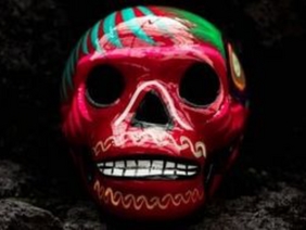 bunte mexikanische Totenmaske vor schwarzem Hintergrund